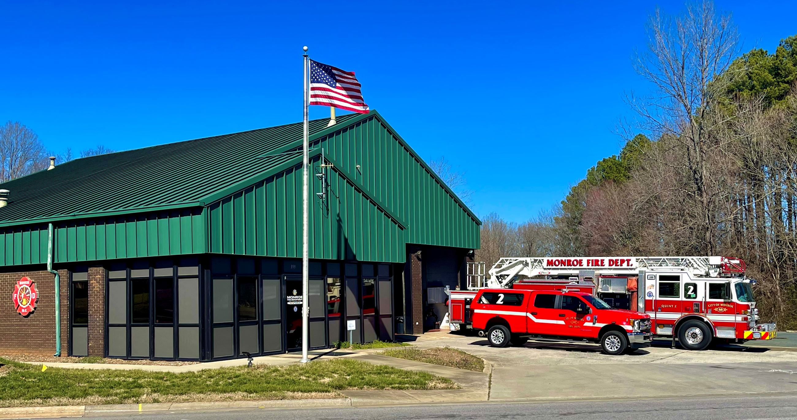 Fire Station 2 with Fire Trucks pulled out and American Flag Flying on Flag Pole