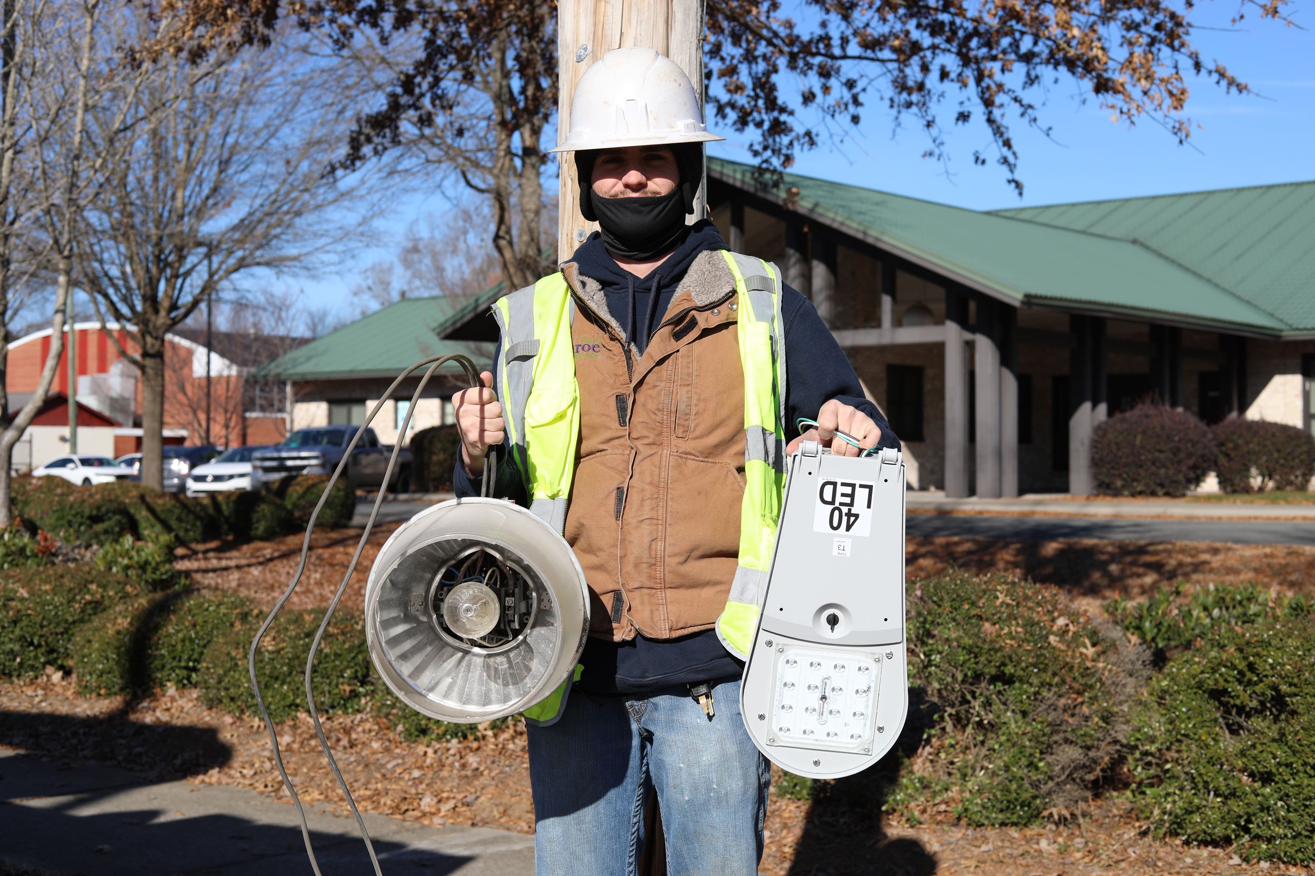 A man holding up two different lights in both hands