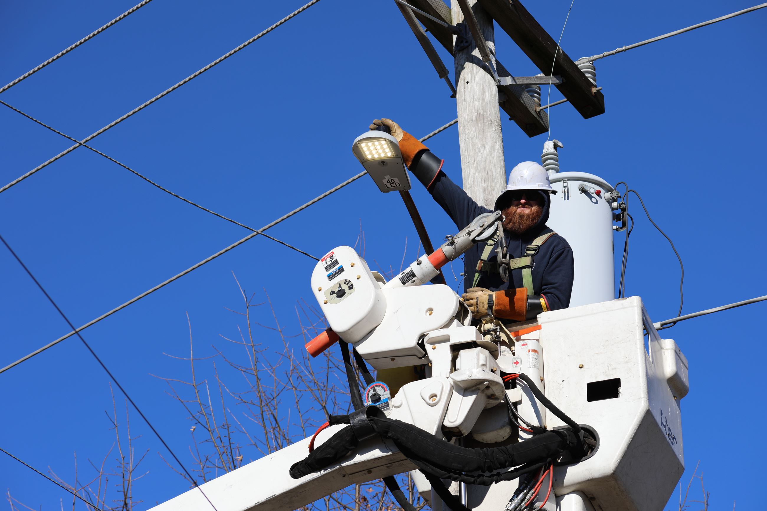 A close up shot of a lineman showing off an LED streetlight