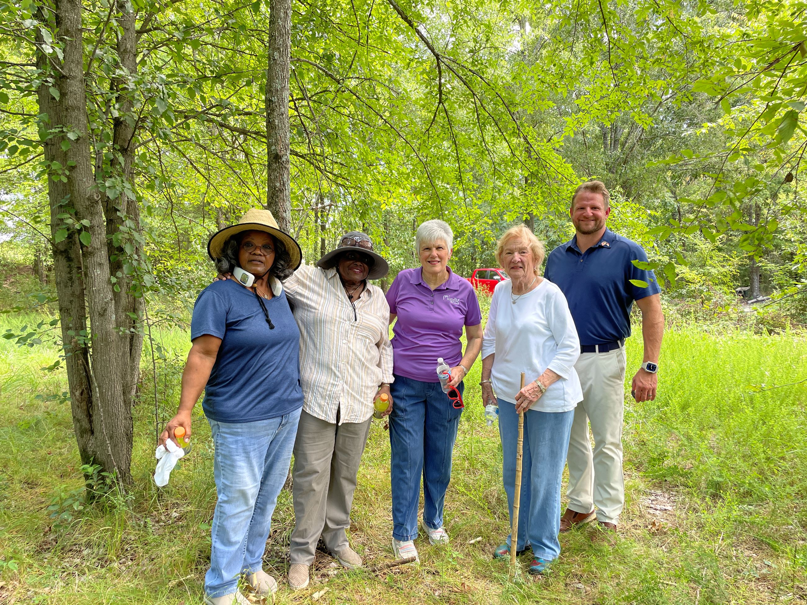 Winchester Revitalization Committee members visit the Winchester site in the woods.