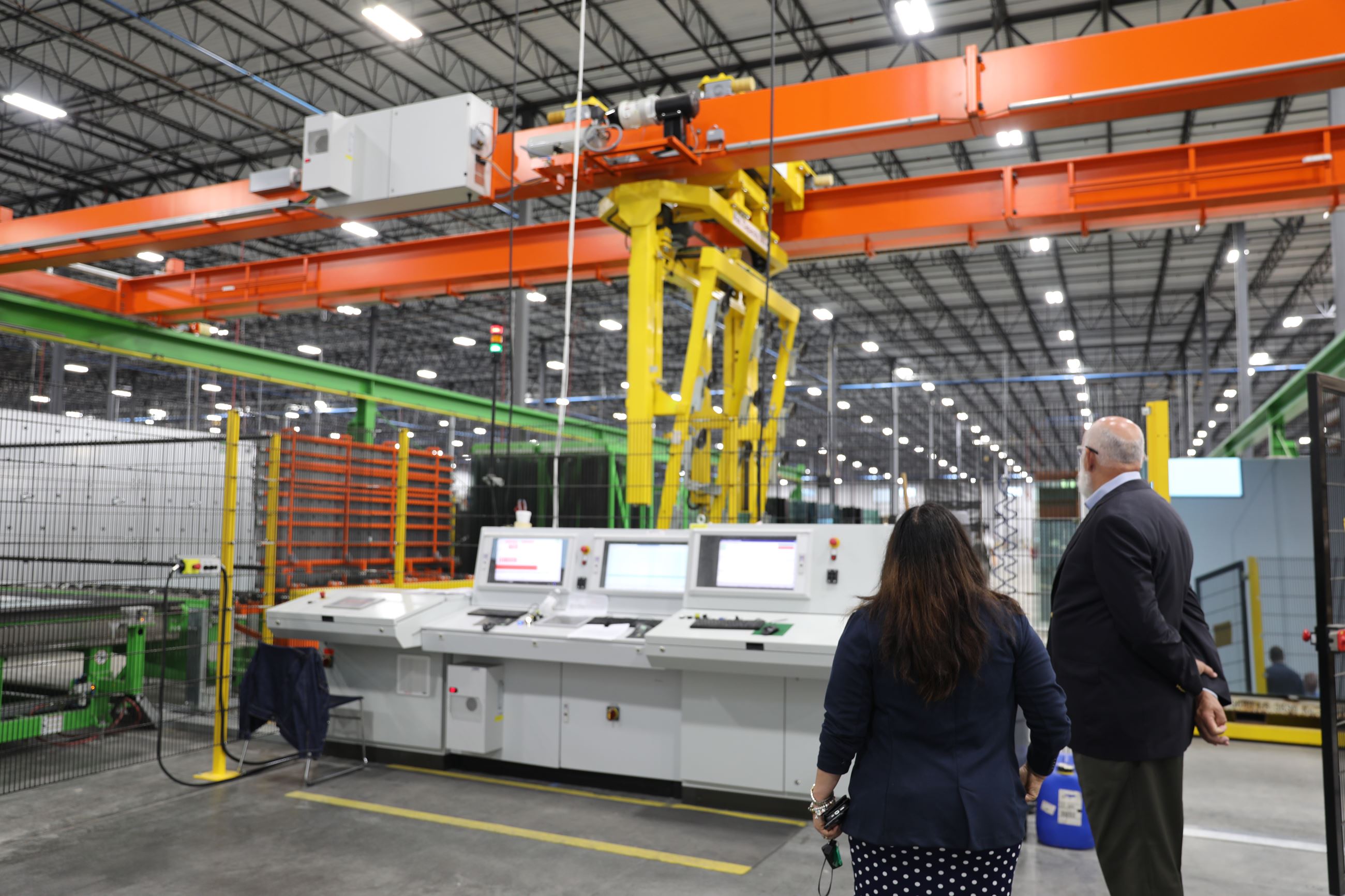 The City Manager and Teresa Campo look at a glass-cutting machine at Windsor Windows.